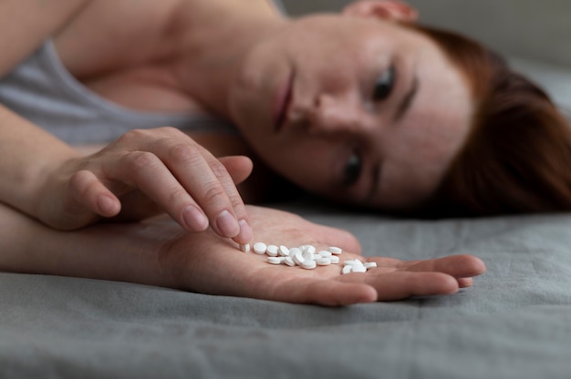 Free Photo close up depressed woman holding pills