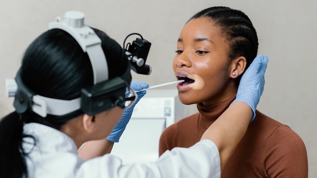 Close up doctor checking patient throat