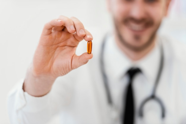 Close-up doctor holding pill