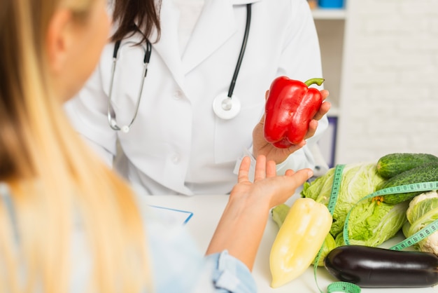 Close-up doctor and patient with vegetables 