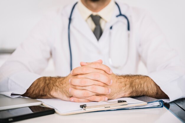 Close-up of a doctor's hand on clipboard