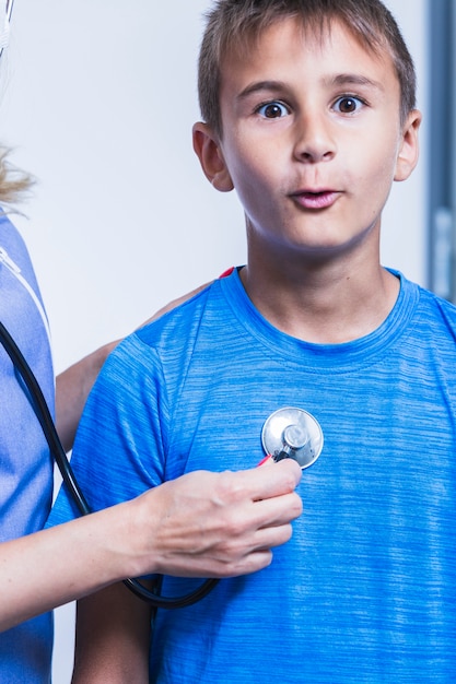 Free photo close-up of a doctor's hand examining boy with stethoscope