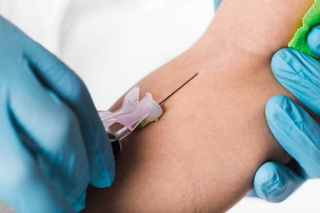 Close-up doctor taking blood sample from sick person