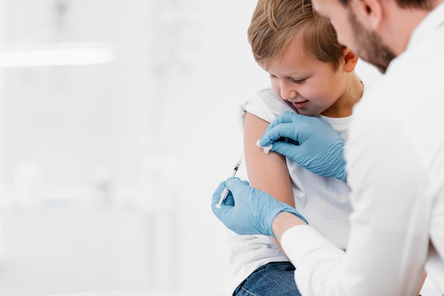 Free photo close-up doctor vaccinating kid