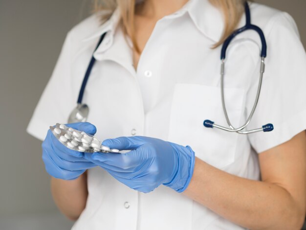 Close-up doctor wearing medical gloves