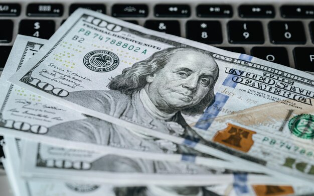 Close up dollar bills on laptop money making concept