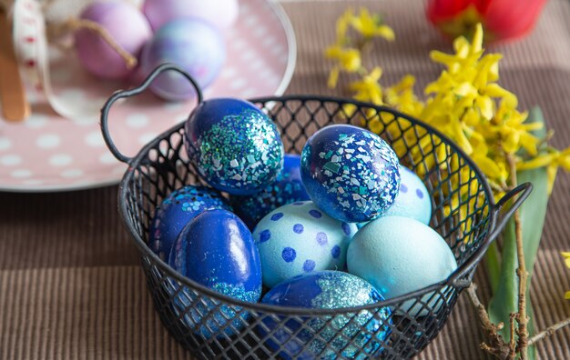 Close up of Easter decorated eggs in a metal basket. Easter holiday concept and ideas for decor.