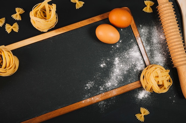 Close-up eggs and pasta on blackboard