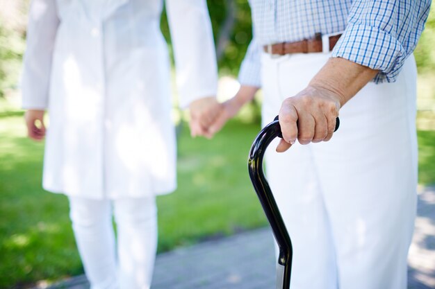 Close-up of elderly woman with walking stick