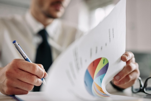 Close up of entrepreneur going through business reports and taking notes in the office