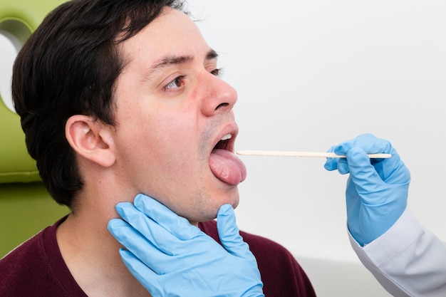 Free photo close up examination with tongue depressor