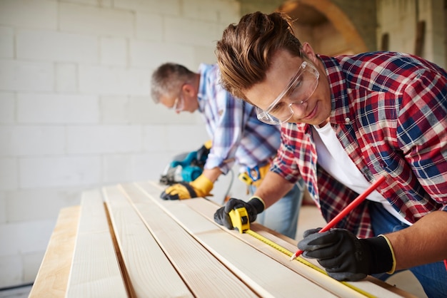 Close up on experienced carpenter and his younger employee