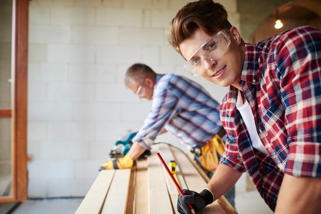 Free photo close up on experienced carpenter and his younger employee