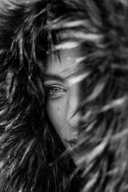 Close up on eyes of a pretty young woman in a big fur coat