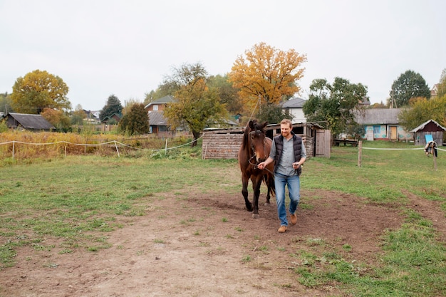 Free photo close up on farmer with beautiful horse