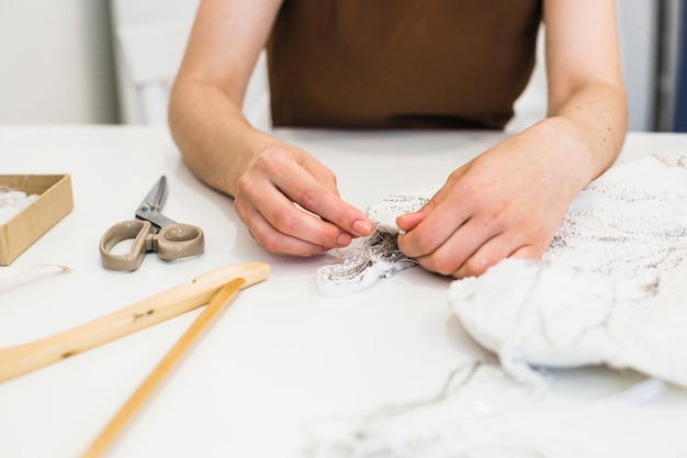 Free photo close-up of fashion designer's hand working on fabric over workdesk