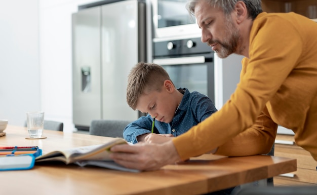 Close up father helping kid with homework