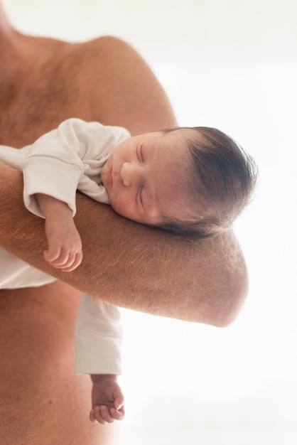 Close-up father holding sleeping son