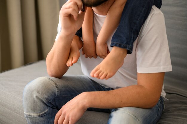 Close-up father holding son on shoulders