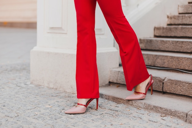 Close up feet in shoes on heels of beautiful sexy rich business style woman in red suit walking in city street, spring summer fashion trend