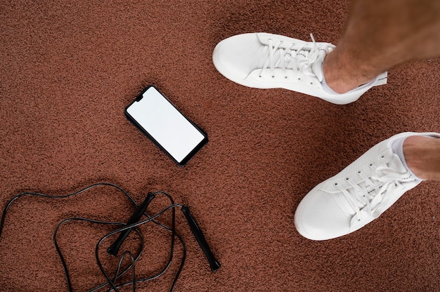 Free Photo close-up feet and smartphone on ground