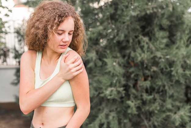 Close-up of female athlete having pain in shoulder