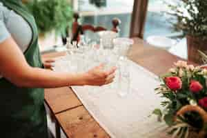 Free photo close-up of a female florist holding glass bottle in floral shop