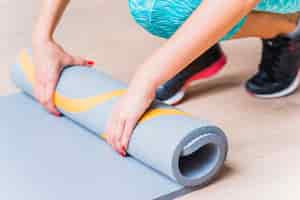 Free photo close-up of a female hand folding yoga mat