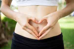 Free photo close-up of female hands shaping heart on belly