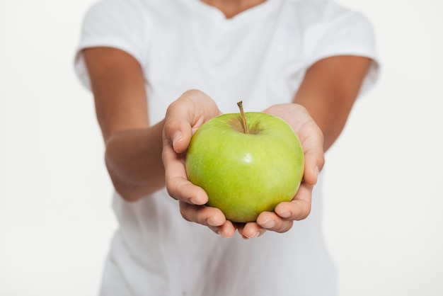 Close up of female hands showing green apple