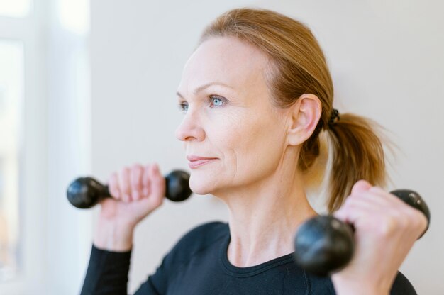 Close-up female holding dumbbells