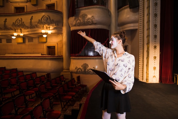 Close-up of female mime holding script rehearsing on stage