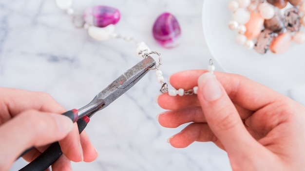 Free photo close-up of a female's hand fixing the metallic ring with pliers