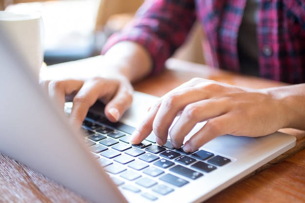 Close-up of female student typing on laptop at table