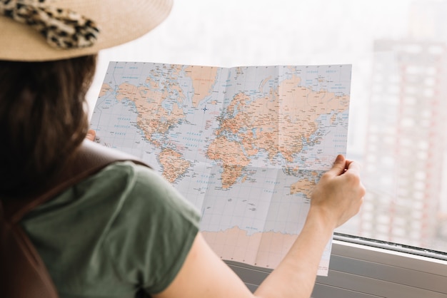 Free Photo close-up of a female tourist reading the map near the window