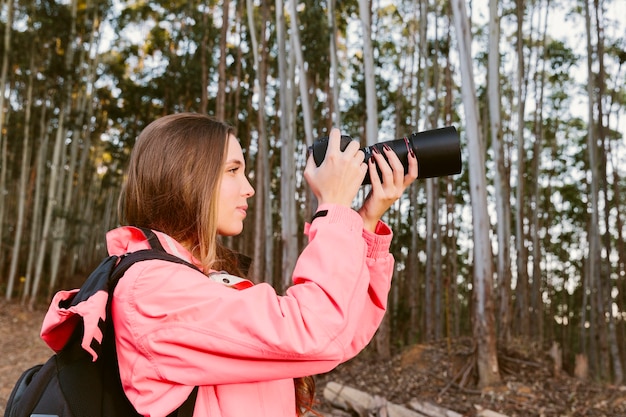 Close-up of female traveler photographing in forest