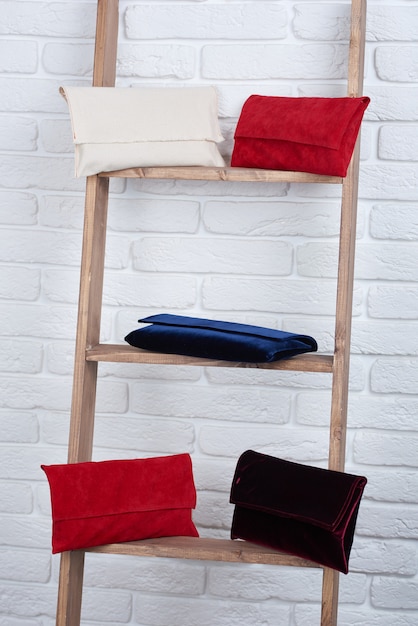 Free photo close-up of five trendy red, white,blue and burgundy women s bags, laying on the white wall.