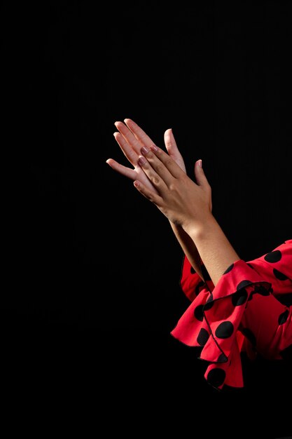 Close-up flamenca clapping hands on black background