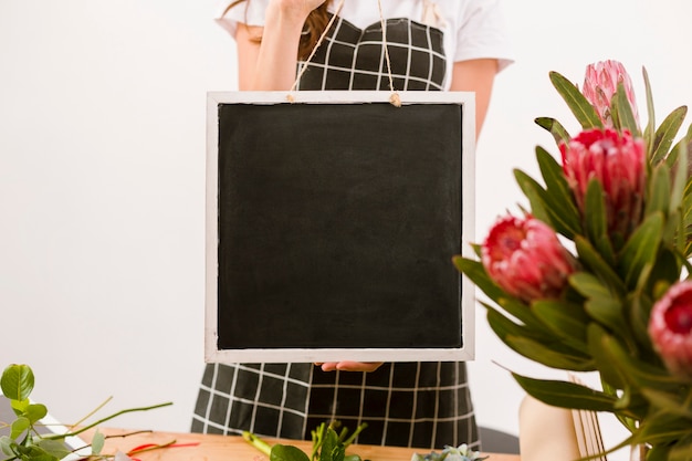 Close-up florist holding a black board