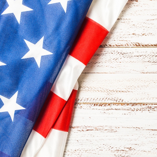 Close-up of folded usa flag with stripes and star on wooden background