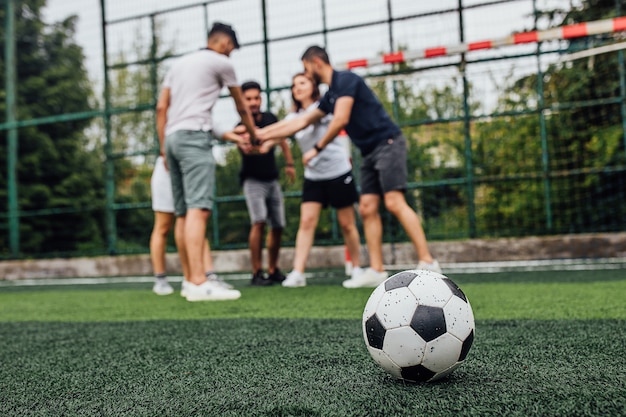 Free photo close up of football ball  on green field.. players going  to playing together..