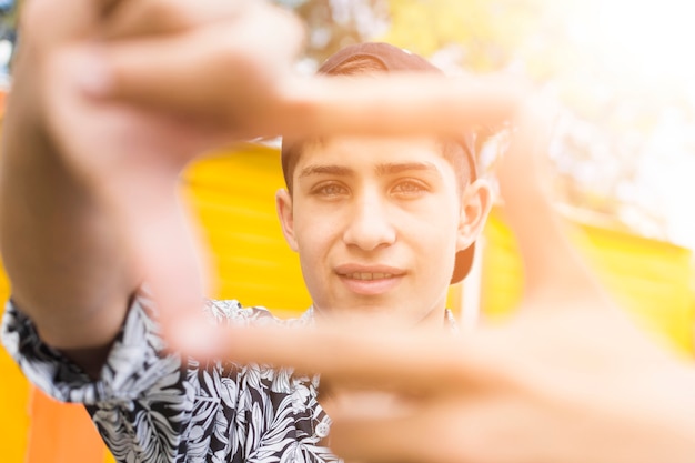 Free photo close-up of frame made from smiling boy's fingers