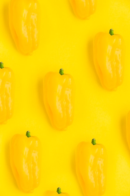 Close-up of fresh bell peppers on yellow backdrop