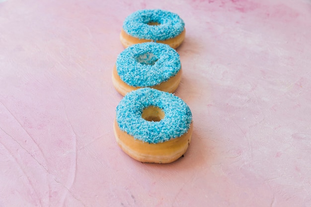 Free photo close-up of fresh blue donuts on pink backdrop