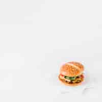 Free photo close-up of fresh burger on tissue paper over white backdrop