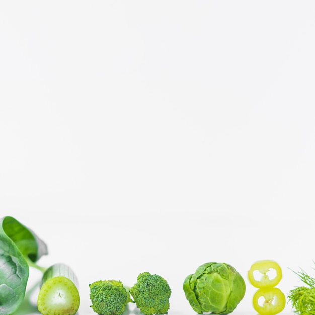 Close-up of fresh green vegetables on white surface