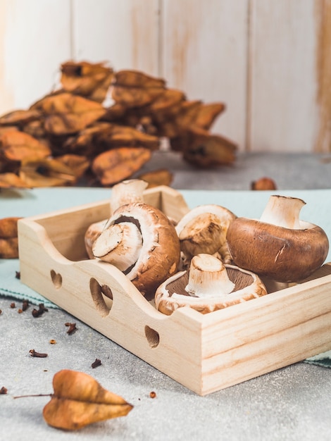 Free photo close-up of fresh mushrooms in wooden tray