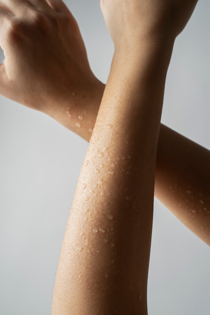 Free Photo close up fresh skin arms with water drops