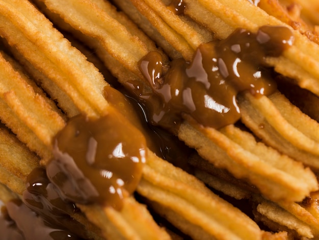 Free photo close-up fried churros with melted chocolate