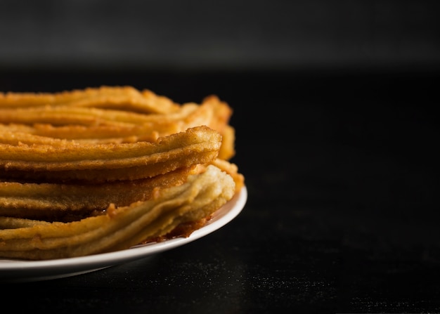 Free photo close-up fried churros with sugar and copy space